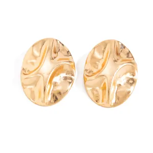 Close-up of gold metal irregular wrinkled petal earrings with textured 3D surface