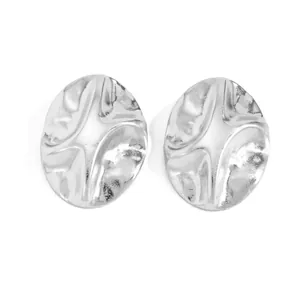 Detailed view of silver irregular pleated metal stud earrings with textured wavy surface