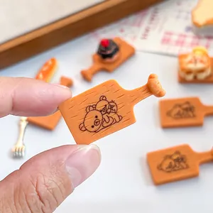 Vue détaillée d'une planche à découper miniature en résine avec gravure d'ourson