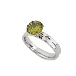 Elegante anillo de acero inoxidable con una circona verde redonda sobre fondo blanco