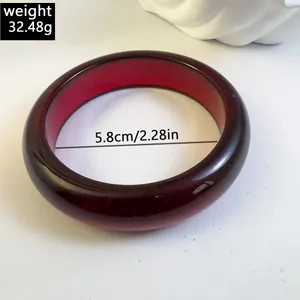 Macro view of a dark red chunky acrylic bangle with 5.8cm diameter and 32.48g weight