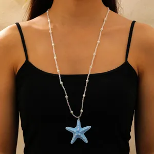 Collier bohème orné d'un pendentif étoile de mer bleue et de perles sur mannequin.