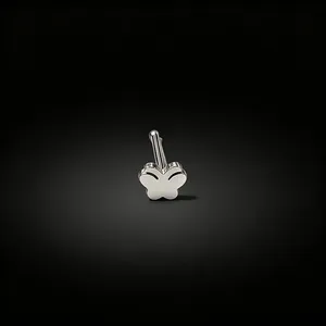 Detailed macro shot of a silver butterfly-shaped surgical steel nose stud piercing.