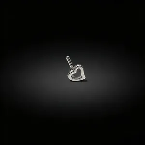 Macro detail view of a polished silver heart-shaped straight bar nose stud piercing