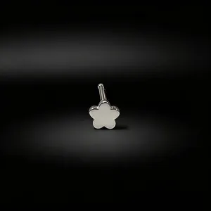 Close-up macro detail of a silver flower-shaped straight bar nose stud on a black background