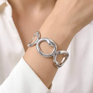 Close-up of minimalist silver stainless steel geometric hollow cuff bracelet on wrist