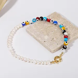 Macro view of handmade evil eye beaded necklace with pearls on a textured stone