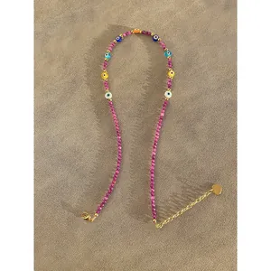 Detailed view of purple beaded evil eye necklace with gold heart charm and extender chain.
