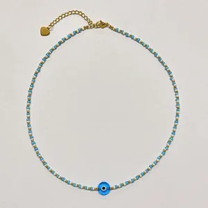 Close-up view of a handcrafted beaded evil eye necklace with light blue and gold accents