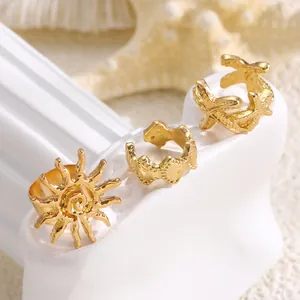 Close-up detail of golden starfish and sun motif ear bone clips in vacation style