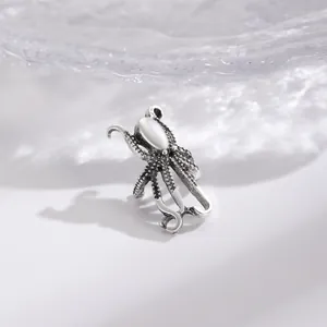 Detailed shot of a vintage silver octopus ear cuff featuring a polished white stone inlay