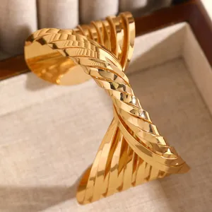Detailed close-up showing texture of exaggerated twisted gold cuff bracelet in punk style
