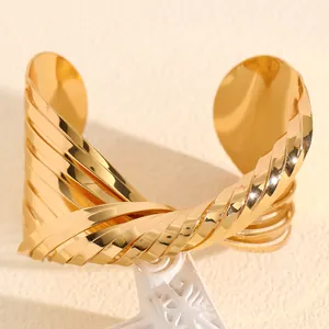 Detailed macro view of a chunky gold-toned twisted cuff bracelet in a punk style