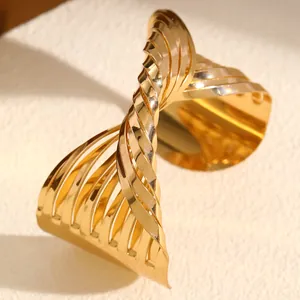 Close-up of a bold golden twisted cuff bracelet featuring a unique ribbed statement design