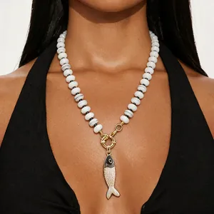 Collana di perle artigianale stile oceano con ciondolo a forma di pesce dorato.