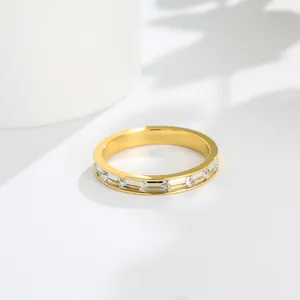 Gros plan d'une bague minimaliste en acier doré avec demi-éternité en zircon cubique