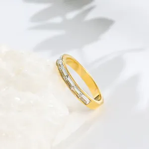 Gros plan d'une bague en acier inoxydable doré avec des zircons taille baguette