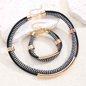 Detail of punk hip hop jewelry set with black and white braided cords and gold metal tubes