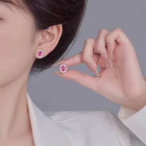 Close-up of elegant rose gold stud earrings featuring pink gemstones and pearl accents