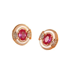 Close-up of elegant rose gold stud earrings with pink gemstone and white shell inlay