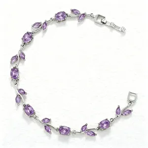 Detailed shot of silver bracelet with leaf motifs and purple crystal accents on white texture
