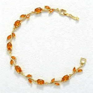 Detailed view of an elegant gold-plated vine bracelet with faceted orange stones