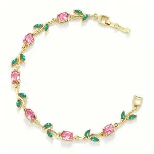 Detailed view of the gold-toned bracelet featuring pink tulip stones and green leaves.