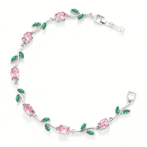 Detail view of an elegant silver-plated vine bracelet with pink stones and green leaf gems.