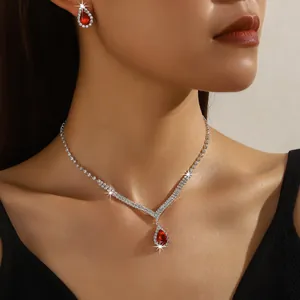 Close-up view of a bridal jewelry set featuring red teardrop zircons and shiny clear stones