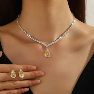 Detailed macro view of silver necklace and teardrop earrings set with sparkling yellow stones