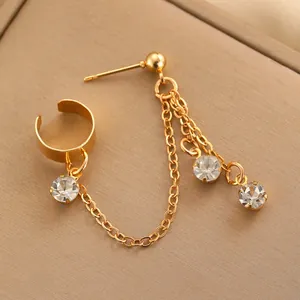 Detail einer goldenen Kettenohrring mit Strasssteinen und Ohrmanschette für Damen