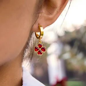 Detailed view of 18K gold-plated titanium earrings with red heart-shaped stones