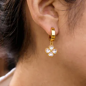 Close-up of 18K gold plated titanium steel clover hoop earrings with crystals on ear