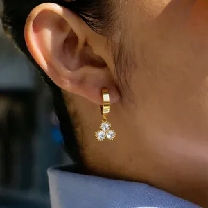 Close-up detail of a 18K gold plated titanium steel hoop earring with clover crystals.