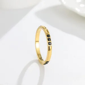 Detail view of a gold titanium steel ring with three inlaid black sparkling stones