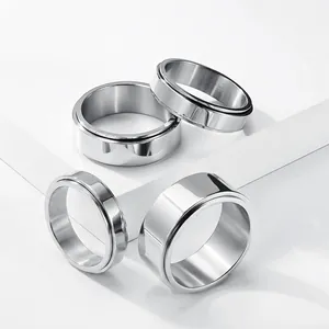 Group of polished stainless steel spinner rings for men and women on white blocks