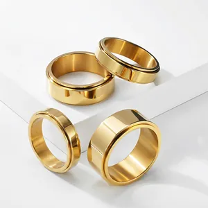 Macro view of four gold-colored stainless steel spinner rings on a white background.