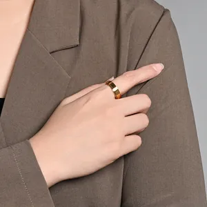 Close-up of gold stainless steel spinner ring worn on hand with a brown blazer