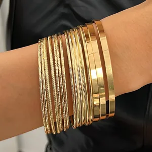 Detailed view of 10-piece gold bangle set with various textures and shiny finishes