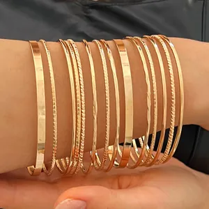 Detailed close-up of 10-piece gold-tone bangle set featuring smooth and textured designs.