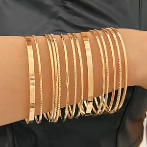 Close-up of a 10-piece gold bangle set with smooth and textured finishes