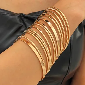 Detail of vintage gold alloy bangle set featuring smooth and textured finishes.