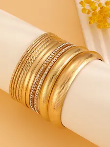 Detailed close-up of a 10-piece ethnic golden alloy bangle set featuring various textures.