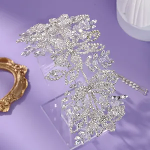 Serre-tête de mariée argenté élégant avec motifs de feuilles en strass sur fond violet.