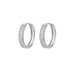 Close-up of silver-tone hoop earrings with multiple rows of sparkling clear stones.
