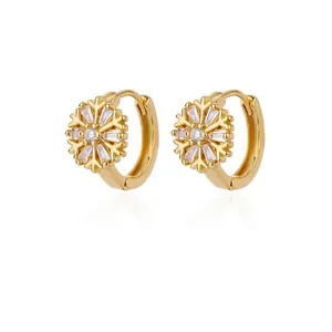 Detailed view of gold snowflake hoop earrings featuring sparkling CZ baguette stones