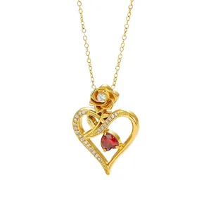 Elegante vergulde hartjesketting met een rode hartvormige edelsteen en roosdetail