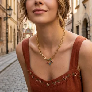 Gold paperclip chain necklace with a colorful zircon star pendant shown on a model