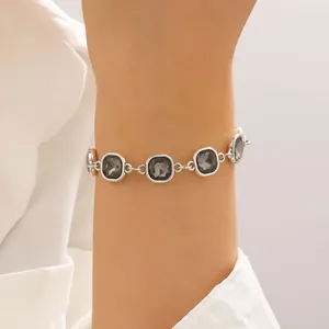 Elegant silver chain bracelet featuring square grey faceted crystals on model wrist
