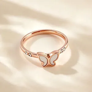 Gedetailleerde close-up van roségouden titanium stalen vlinderring met witte schelp en zirkoon